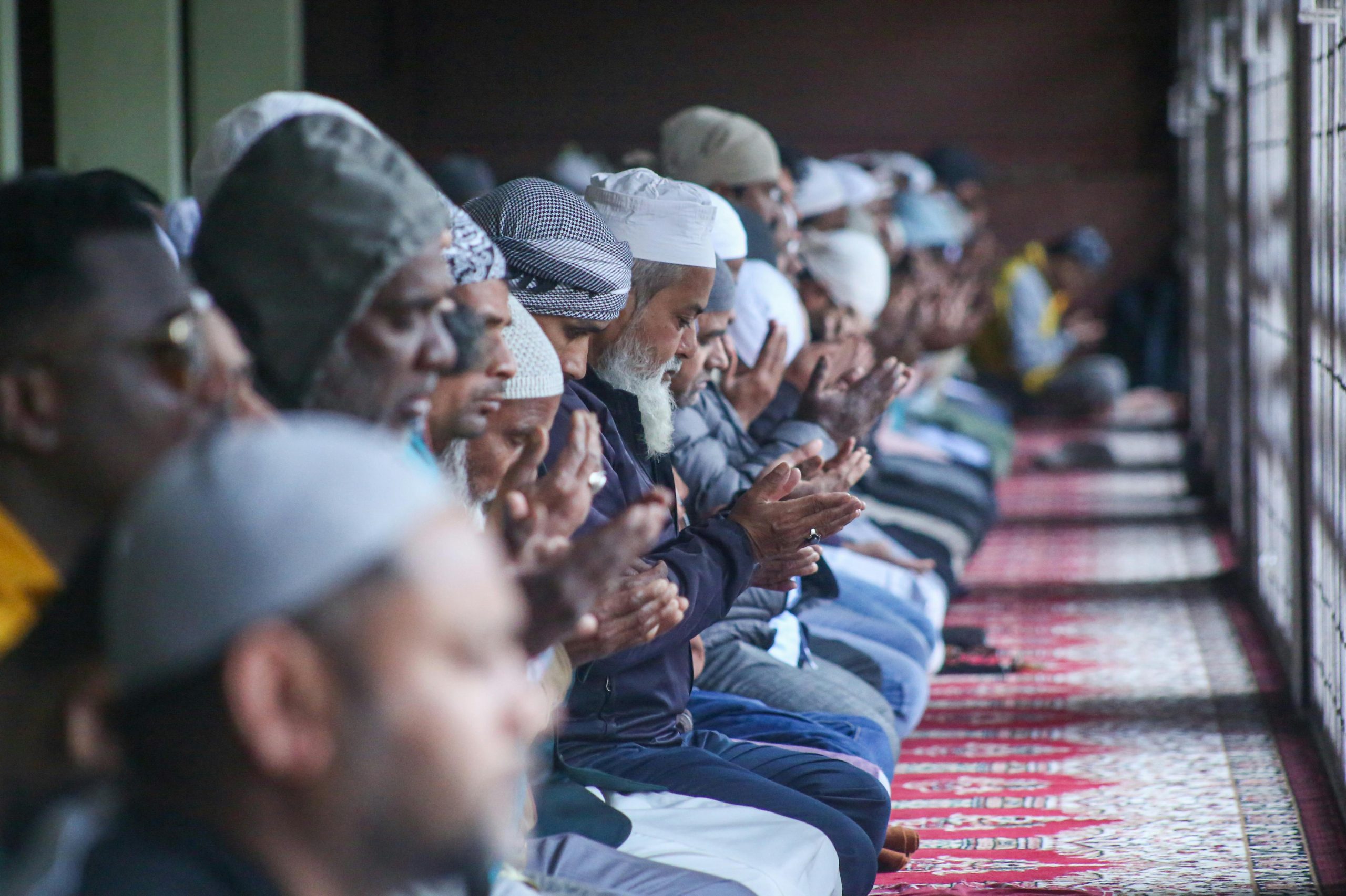 Muslim worshippers making dua during prayer inside mosque