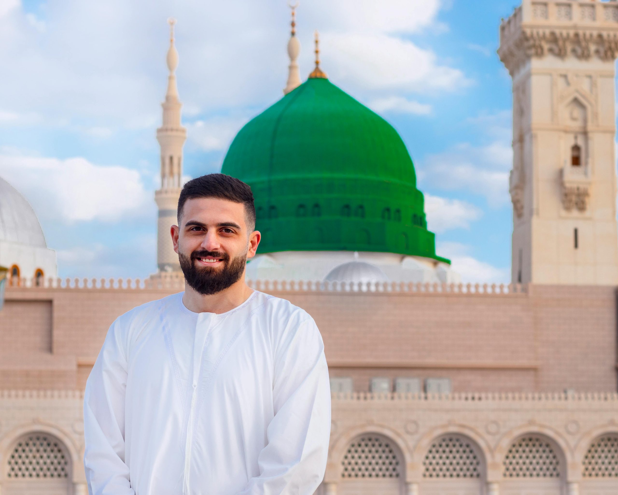 Pilgrim standing in front of Masjid Nabawi green dome in Madinah