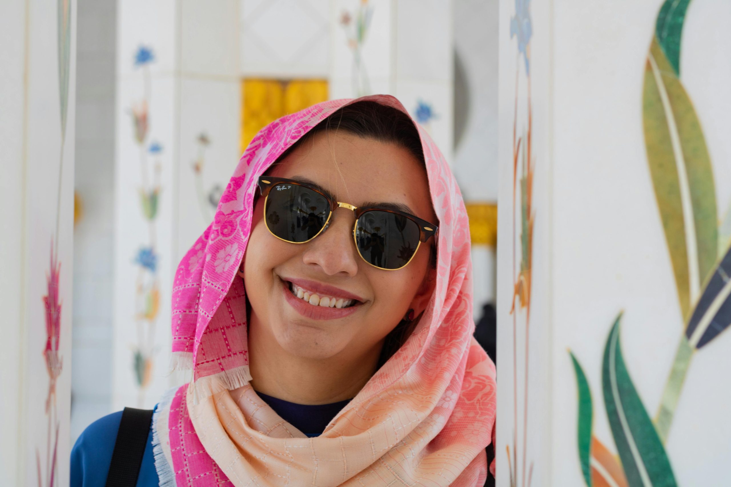 Smiling Muslim woman traveler wearing a pink scarf and sunglasses