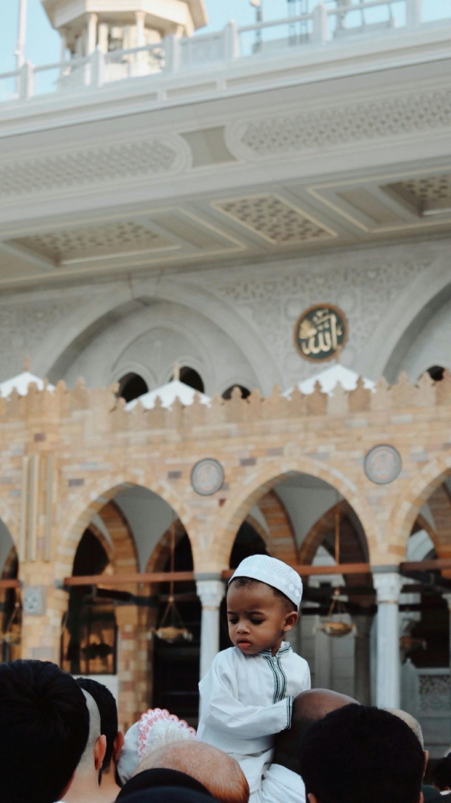Young child pilgrim visiting a mosque courtyard during pilgrimage