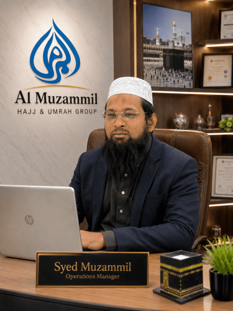 Syed Muzammil, Operations Manager at Al Muzammil Haj Umrah Group, seated in a professional travel office environment.