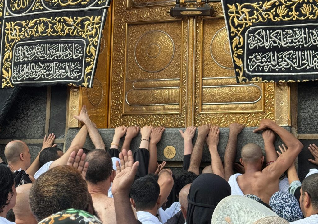 Umrah and Tours Packages Pilgrims touching the sacred Kaaba door during Umrah pilgrimage in Makkah and performing tawaf around the Kaaba during Umrah pilgrimage